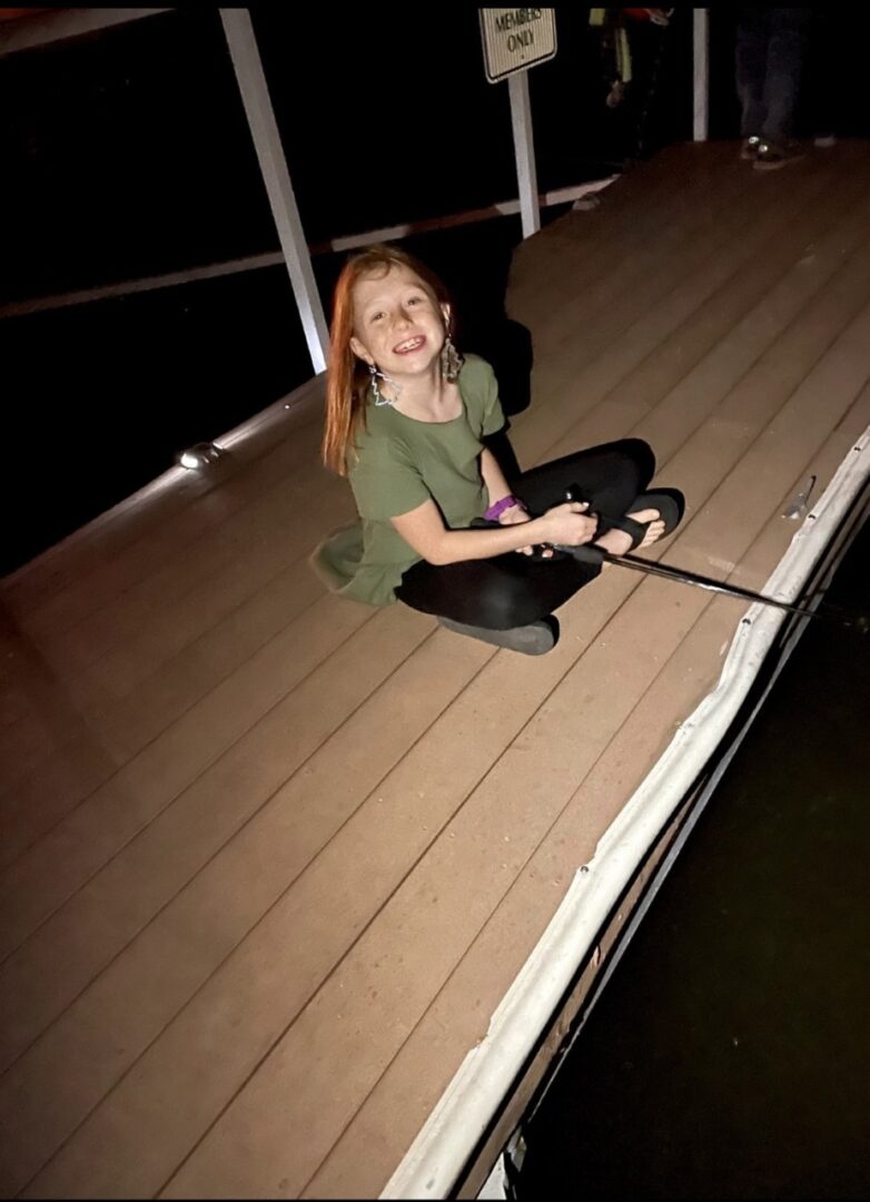 A girl sitting on the deck of a boat.