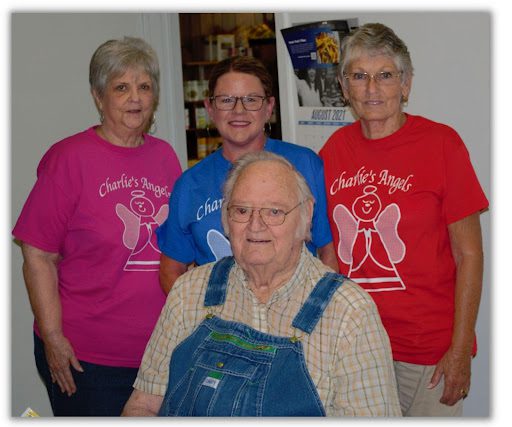 A group of people wearing matching shirts and aprons.