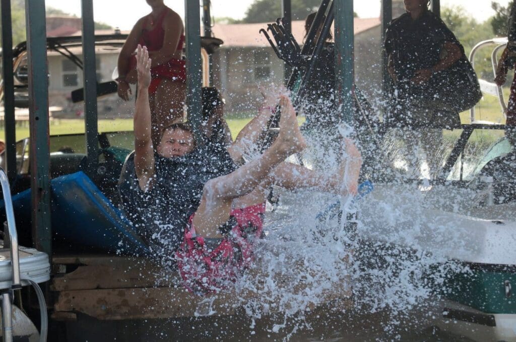 A child splashing water joyfully while sliding.