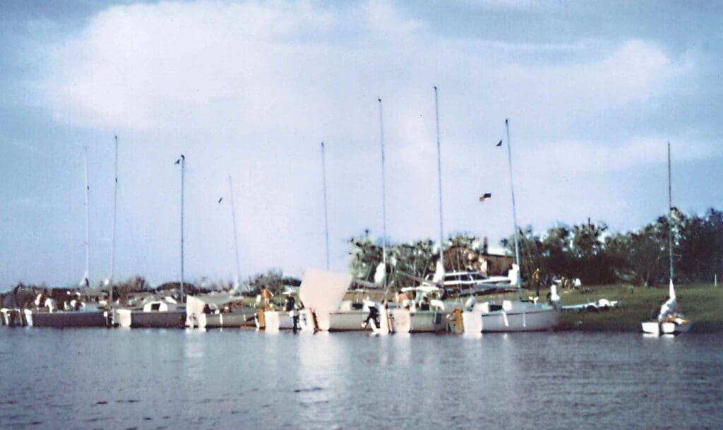 Small boats docked by a calm waterfront under a partly cloudy sky.