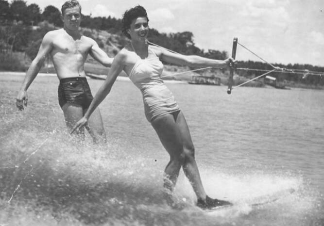 A man and woman water skiing in the ocean.