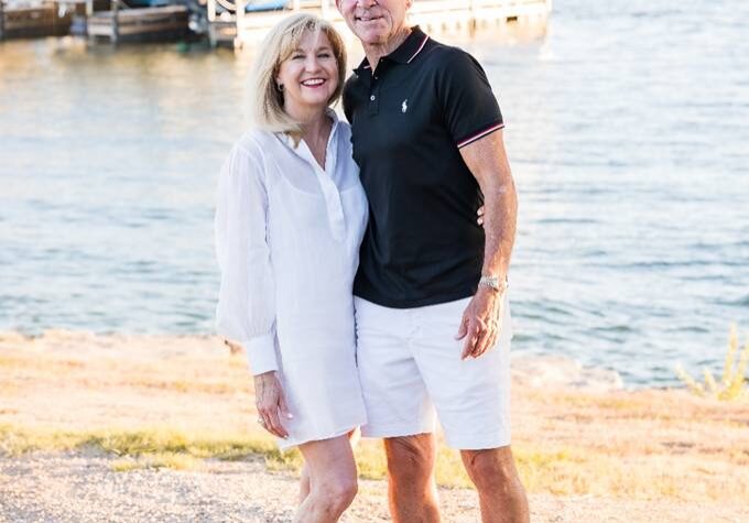 A man and woman standing next to each other on the beach.