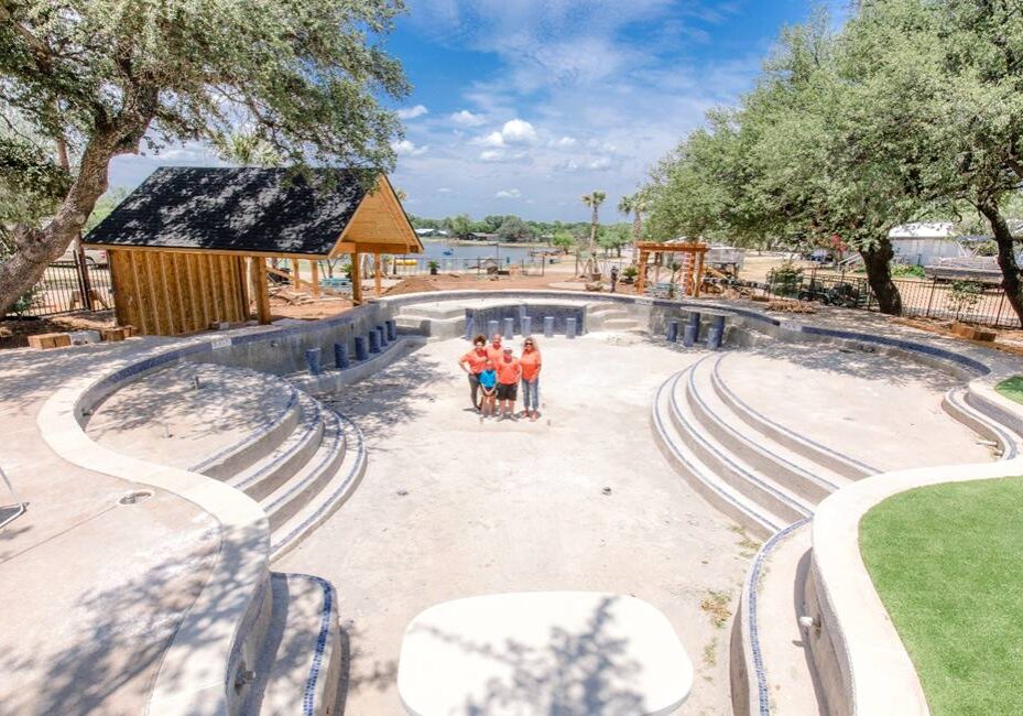 A group of people sitting on top of a cement bench.