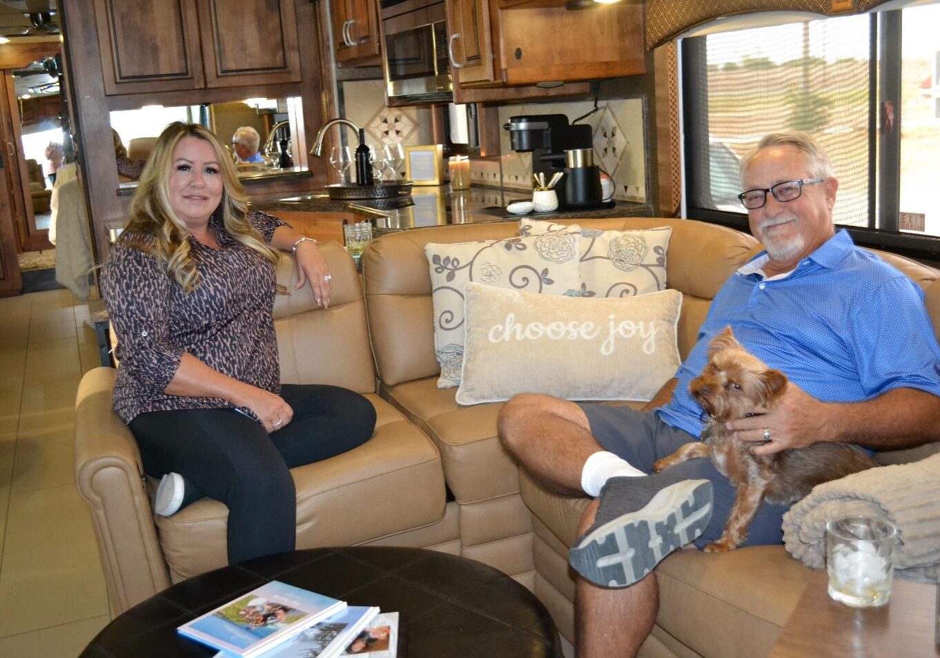 A man and woman sitting on the couch with their dog.