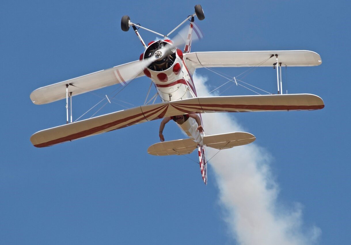 A small airplane flying in the sky with smoke coming out of it.